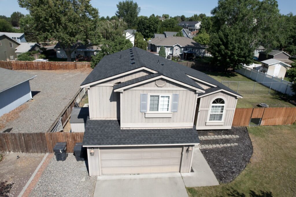 front view of tan home with black roof