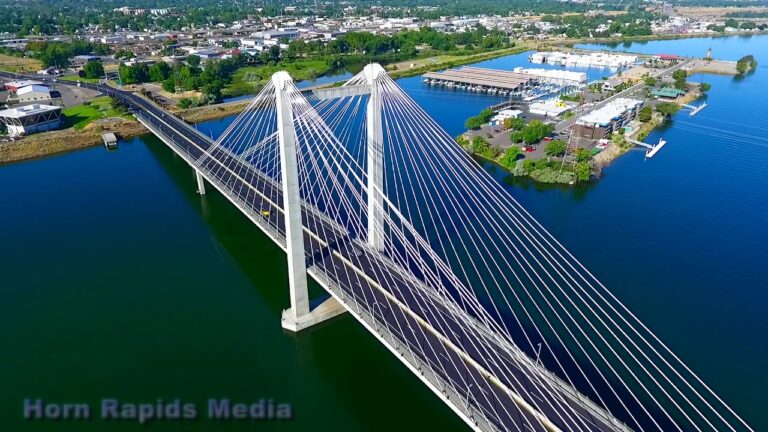 Alpine Roofing Bird's eye view of a white-color suspension bridge over a river.