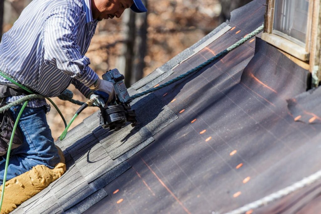 construction worker securing shingles
