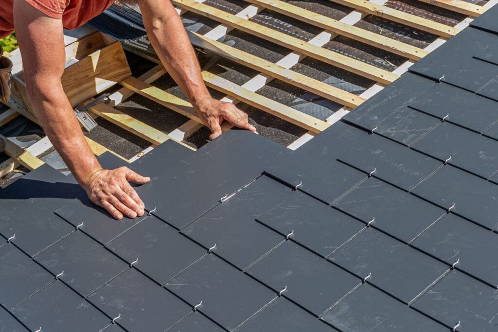 Man installing tiles on roof