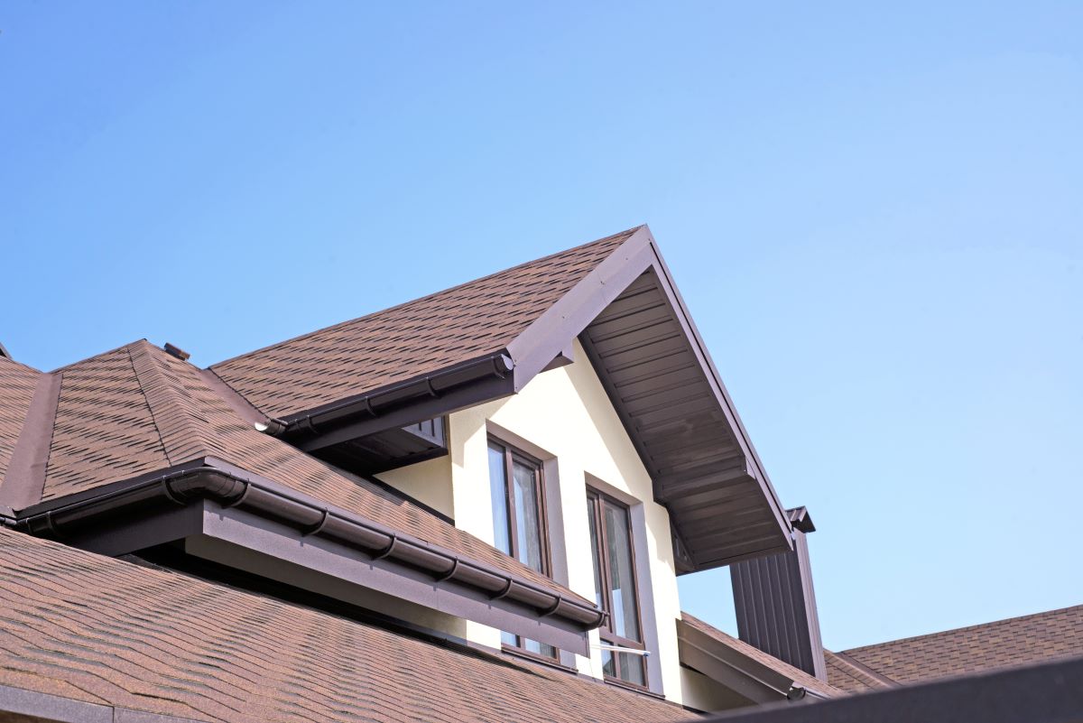 roof with brown shingles against blue sky
