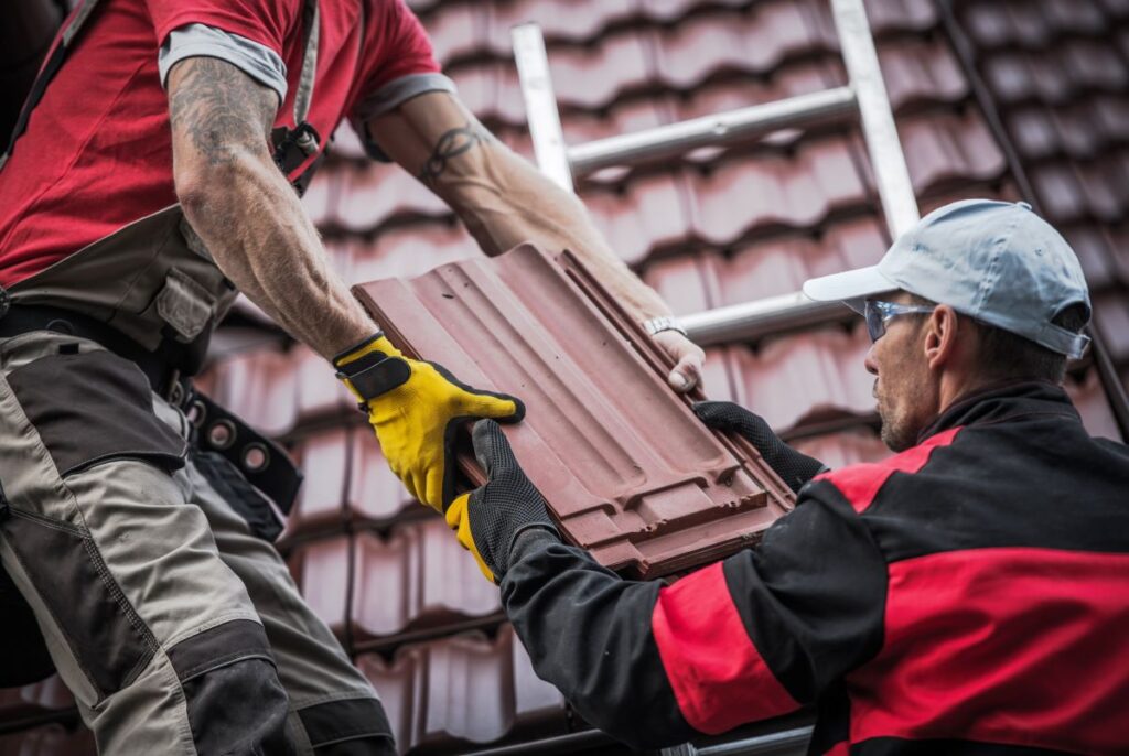 Roofers working together to install tiles