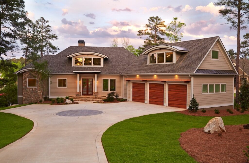 Exterior of beautiful modern home with dormer windows in roof and long driveway