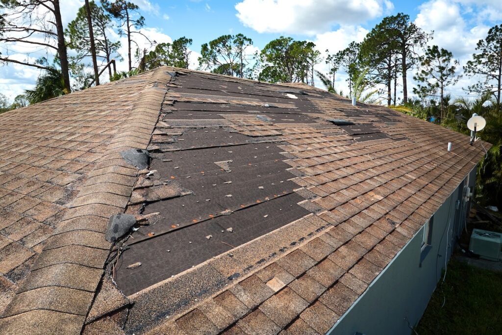 Damaged house roof with missing shingles