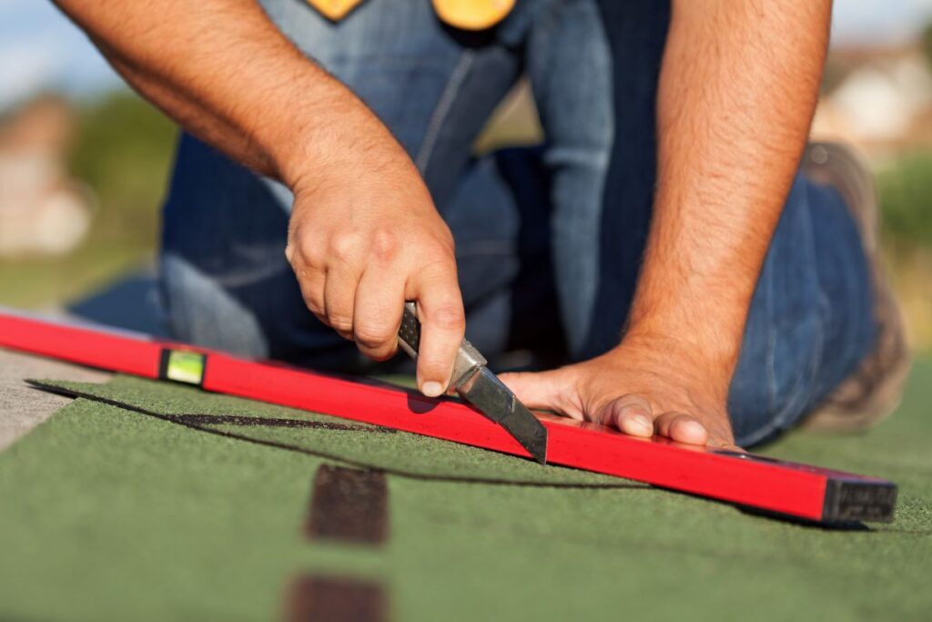 worker installing shingles