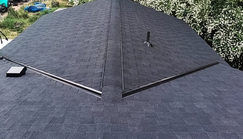 Close up of dark grey asphalt shingles and flashing