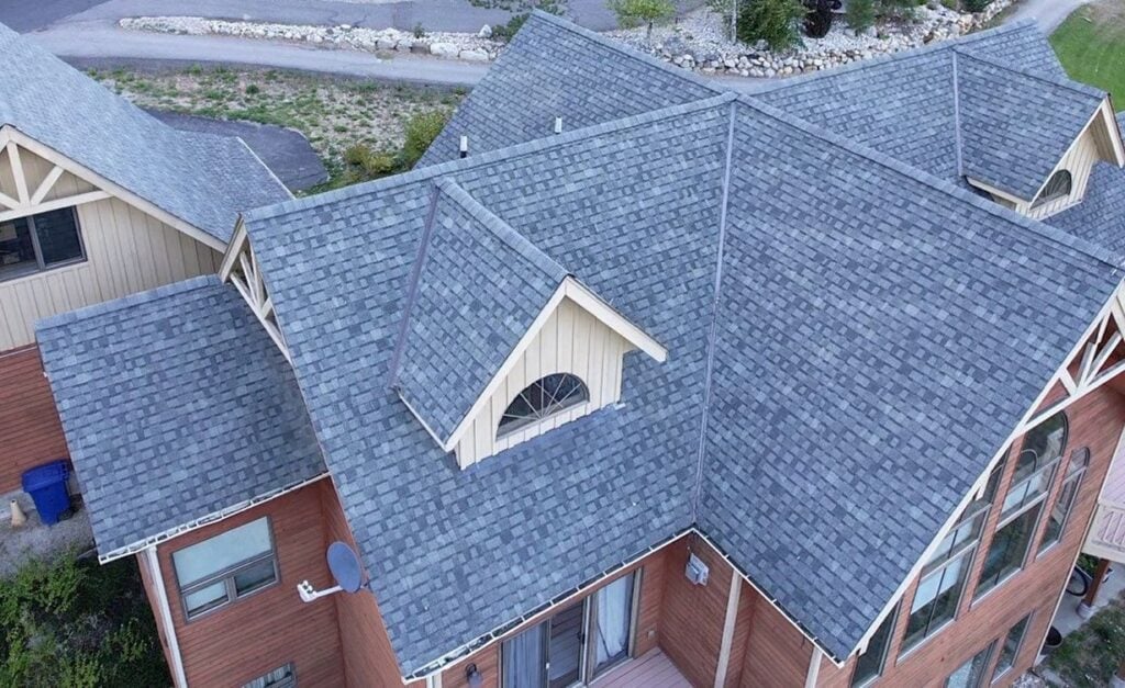 Aerial view of a large house with a grey asphalt roof