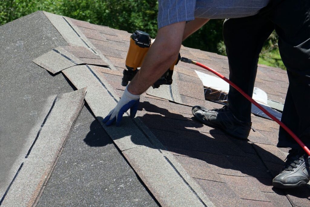 should i stay home during roof replacement worker installing shingles
