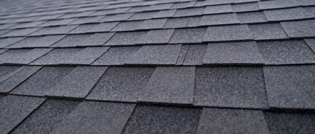 Selective focus texture of dark gray asphalt roof shingles