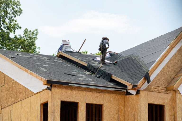 roofing companies in Sandpoint ID worker replacing new shingles