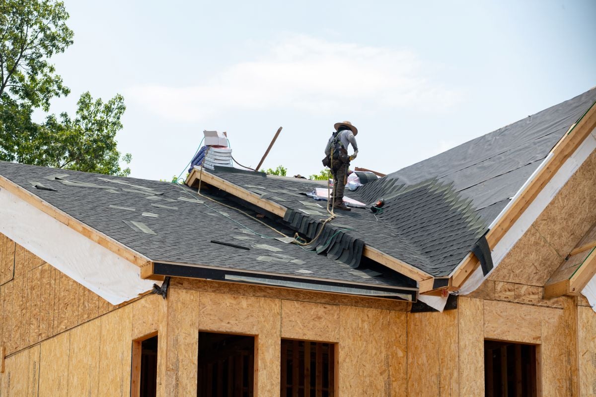 roofing companies in Sandpoint ID worker replacing new shingles