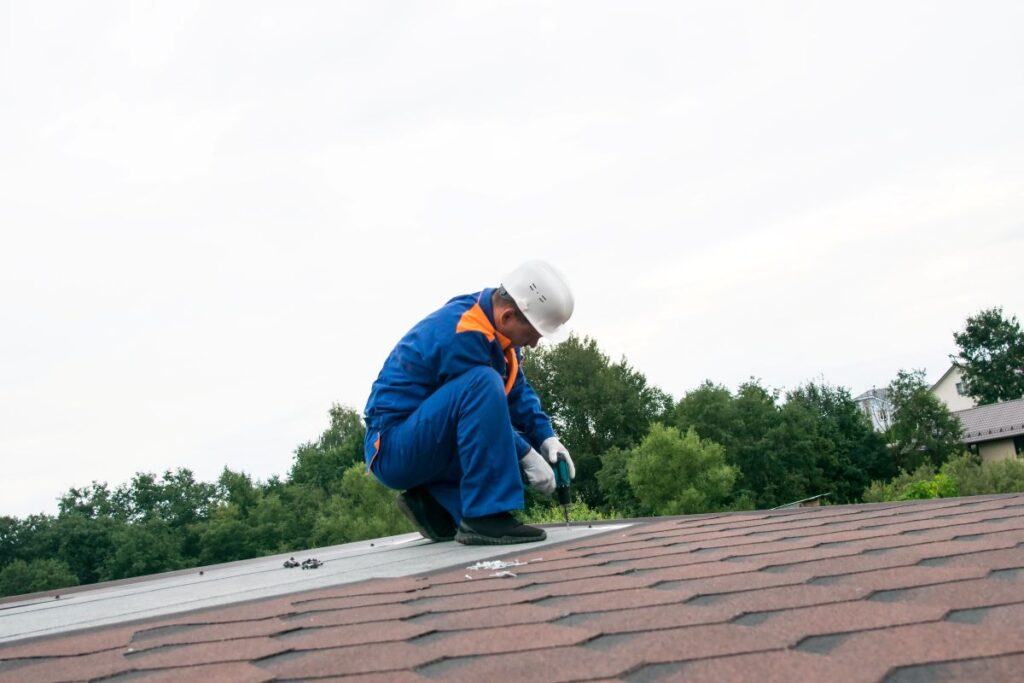 how much does it cost to fix a roof leak worker repairing shingles
