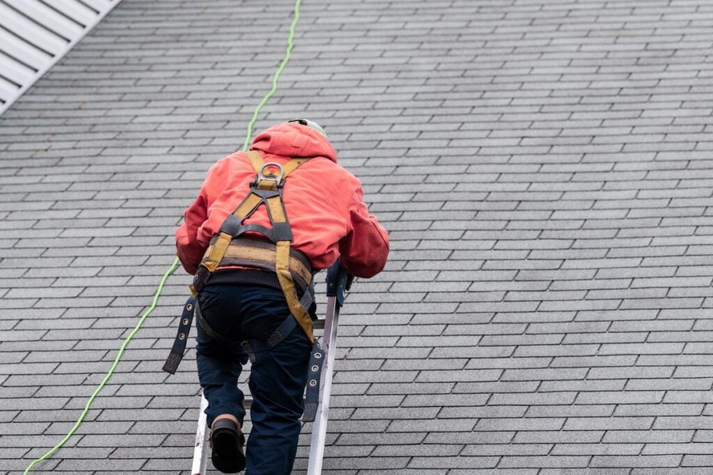 dryer vent on roof shingles roof worker on top for inspection